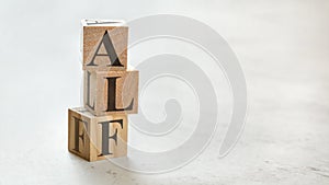 Pile with three wooden cubes - letters ALF for Always Listen First on them, space for more text / images on right side photo
