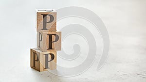 Pile with three wooden cubes - letters PPP meaning Praise Picture Push on them, space for more text / images at right side