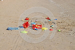 a pile of toys sit in the sand at the beach