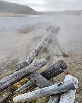 A pile of tree trunks surrounded by smoke, on a sunny day in the forest of Mount Hood, Oregon