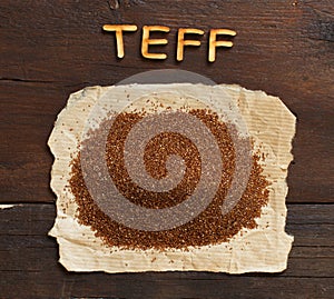 Pile of uncooked teff grain with wooden word