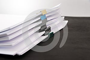 A pile of unfinished documents on an office desk, a desk of business paper. stack with documents on a black background. Close-up.
