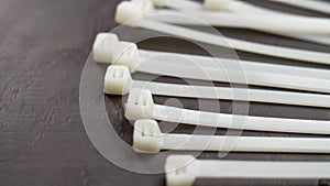 Pile of unused nylon cable ties on a wooden background close up