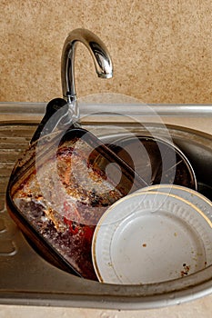 Pile of unwashed, dirty dishes in the sink. Mess in the kitchen