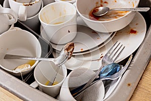 Pile of unwashed, dirty dishes in the sink. Mess in the kitchen. Dirty kitchenware, plates and mugs. Chaos at home