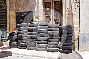 Pile of used car rubber tires near auto garage on street