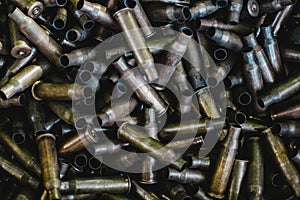 Pile of used rifle cartridges 7.62 mm caliber, many empty bullet shells, assault rifle bullet shell, military background, top view