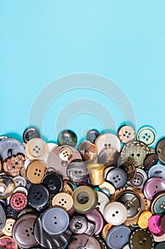 Pile of various buttons on blue with copyspace