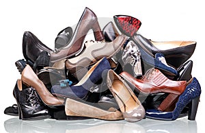 Pile of various female shoes over white