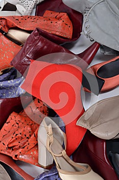 Pile of various multicolored female shoes background