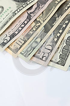 Pile of various US american dollar money bills spread as fan sorted by value of dollar banknotes on white background.