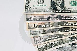 Pile of various US american dollar money bills spread as fan sorted by value of dollar banknotes on white background.