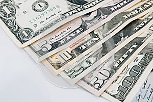 Pile of various US american dollar money bills spread as fan sorted by value of dollar banknotes on white background.