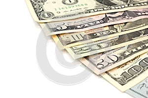 Pile of various US american dollar money bills spread as fan sorted by value of dollar banknotes on white background.