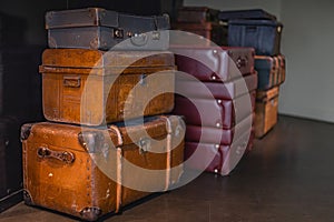 Pile of vintage, warn travel suitcases or trunks on the floor