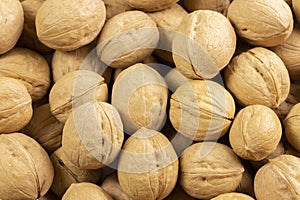 Pile of walnuts in shell, background wallpaper close-up. Nuts structured walnut shell texture. Healthy Protein Meal