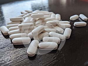 Pile of white pills on table, medicine, pharmaceuticals