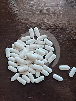 Pile of white pills on table, medicine, pharmaceuticals