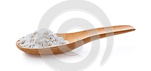 Pile of white wheat flour in wooden spoon on white background