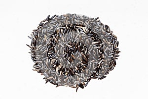 Pile of whole-grain niger seeds on gray