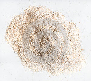 Pile of whole-grain wheat flour close up on gray