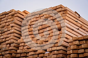 A pile of wood with a layer of snow on top, showcasing the wintry weather conditions. A tall and sturdy pile of wooden