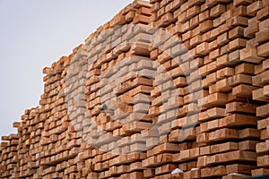 A pile of wood with a layer of snow on top, showcasing the wintry weather conditions. A tall and sturdy pile of wooden