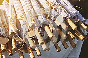 A pile of wooden umbrella for wedding souvenir with empty name tag, close-up
