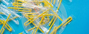 Pile of yellow drinking straws on a blue background