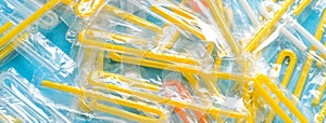 Pile of yellow drinking straws on a blue background