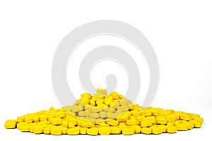 Pile of yellow ovoid-rectangular shape tablet pills isolated on white background with copy space. Medicine for relief pain