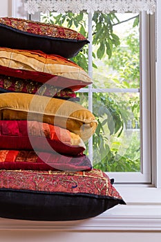 Piled Authentic Pillows In Front Glass Window