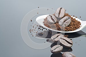 piled harmony coffee bean roast and ground coffee in spoon on shiny black backgrounds with shadow reflexing