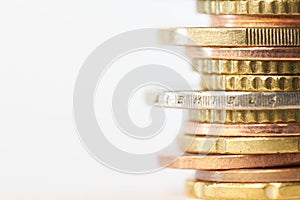 Piled up euro coins on table with white background and copy space