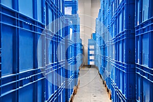 Piles of blue plastic containers in a warehouse in Germany.