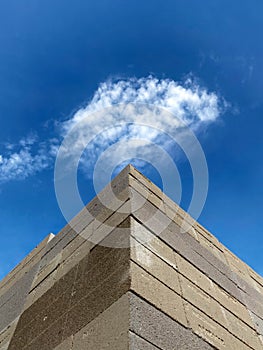 Piles of bricks arranged neatly under a cloudy blue sky
