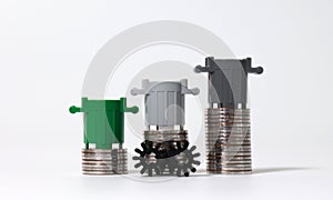 Piles of coins with miniature trash cans and miniature cogwheel.