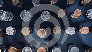 Piles of coins (polish zloty, grosze, PLN) on a black, reflective surface seen from the top.