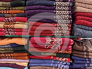 Piles of colorful towels with motifs like typical Indonesian batik