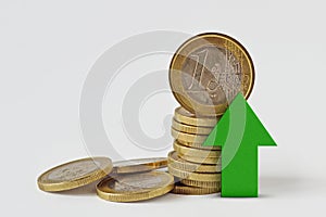 Piles of euro coins with green raising arrow on white background - Money growth concept