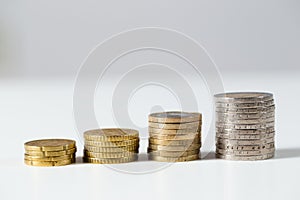 Piles of euro coins prospering on white background. photo