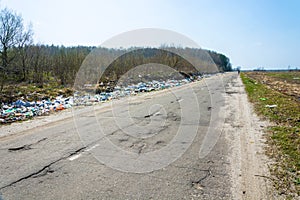 Piles of garbage along the bad asphalt road, Russia.