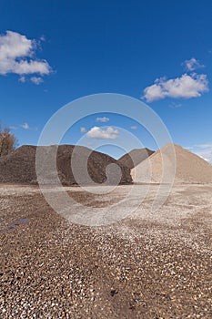 Piles of Gravel at Construction Site under Bright Blue Sky