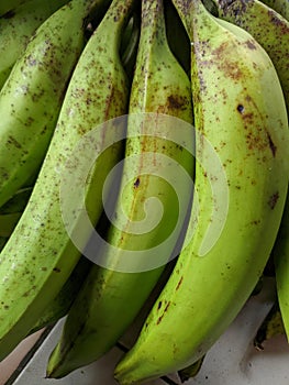 Piles of green bananas are sold in the local Indonesian market. Banana branch at the market. files 3