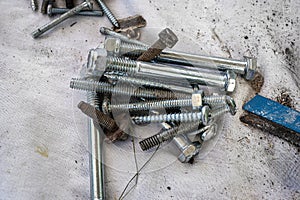 Piles of nuts bolts cutting blades and different hardware on a drop sheet