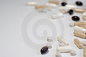 Piles of pills and capsule on white background. Selective focus