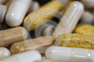 Piles of pills and capsule on white background. Selective focus