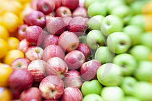 Piles of Red and Green Apples with Oranges