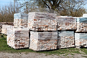 Piles of restored bricks on pallets, outdoors.Construction Materials.