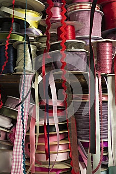 Piles of Rolls of Satin Ribbon Tailor Supply on Wooden Shelf